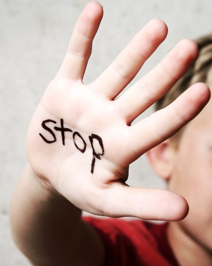kid's hand with the word stop in it