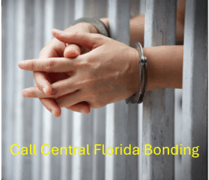 handcuffs on a set of hands and hands in jail cell